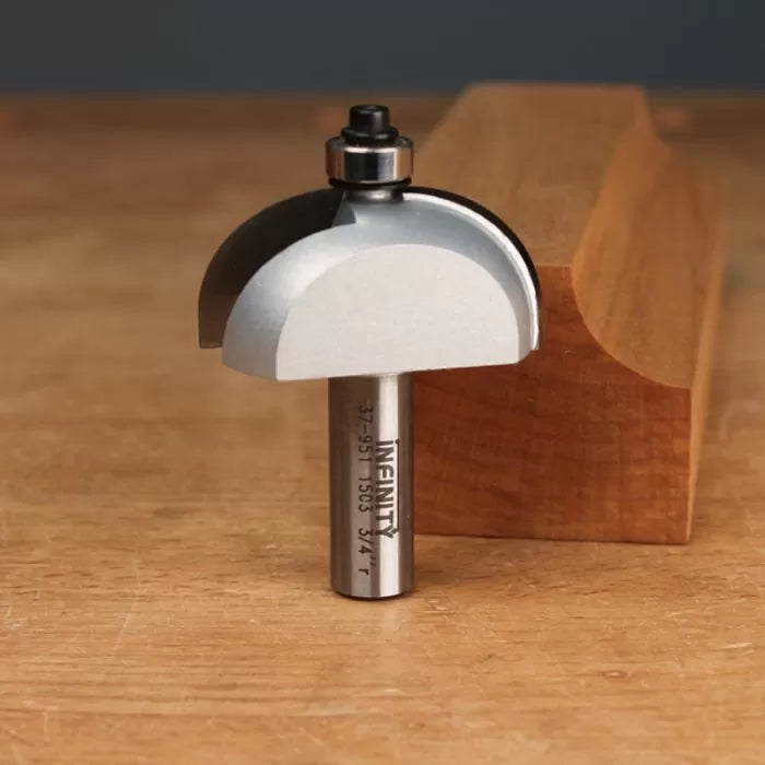 Roundover router bit with bearing on wooden table, sample wood profile in background.