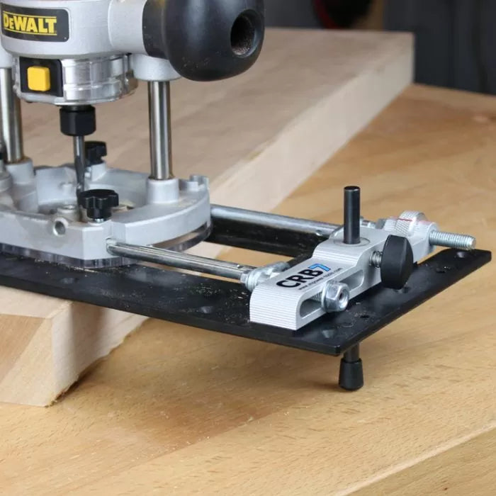Woodworking router with edge guide attachment on a wooden workbench