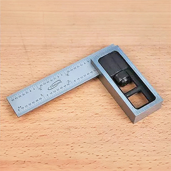 Precision steel woodworking square with ruler on a wood surface