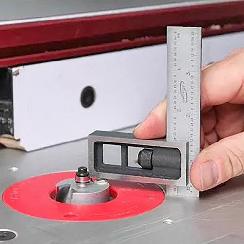 Hand using precision square to measure router bit height on a woodworking router table