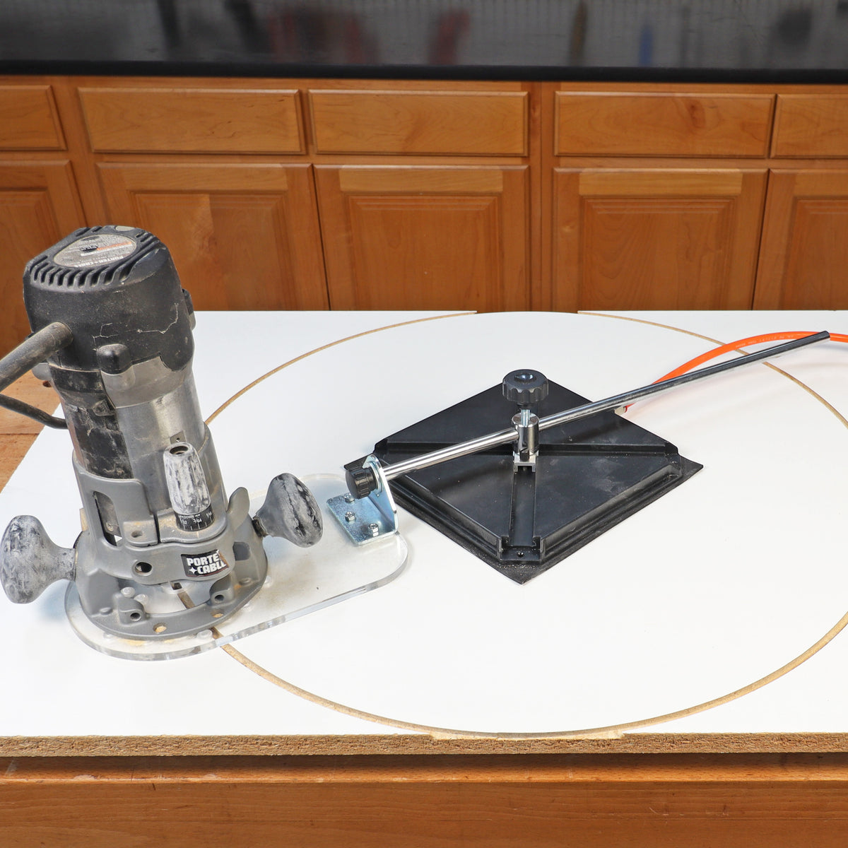 Wood router and circle cutting jig on workbench for precise woodworking cuts