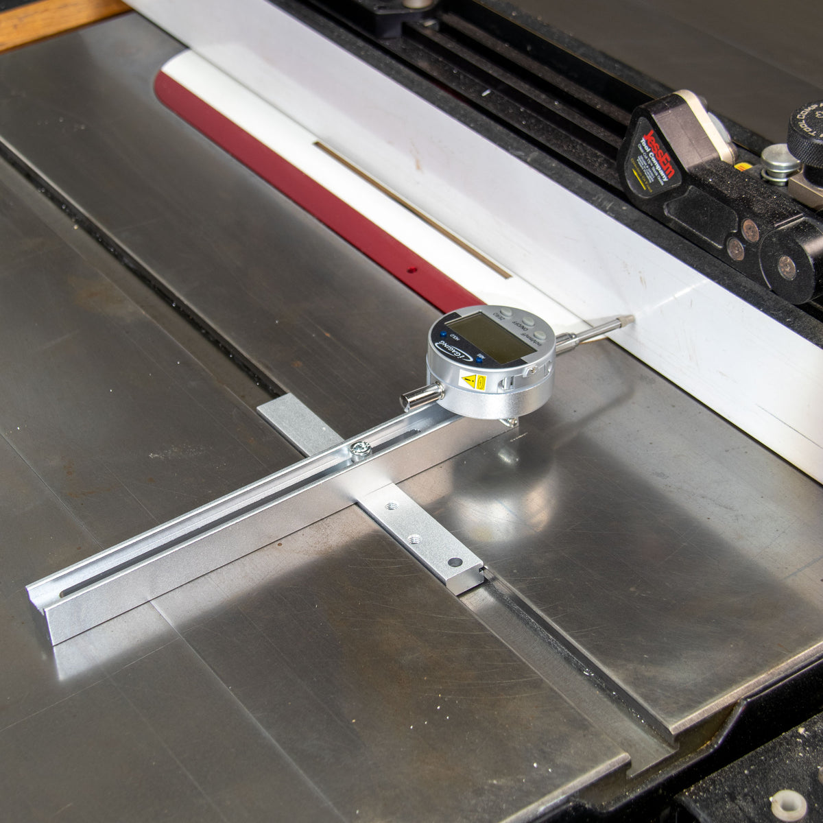 Digital measuring gauge setup on a table saw to measure table saw fence straightness.