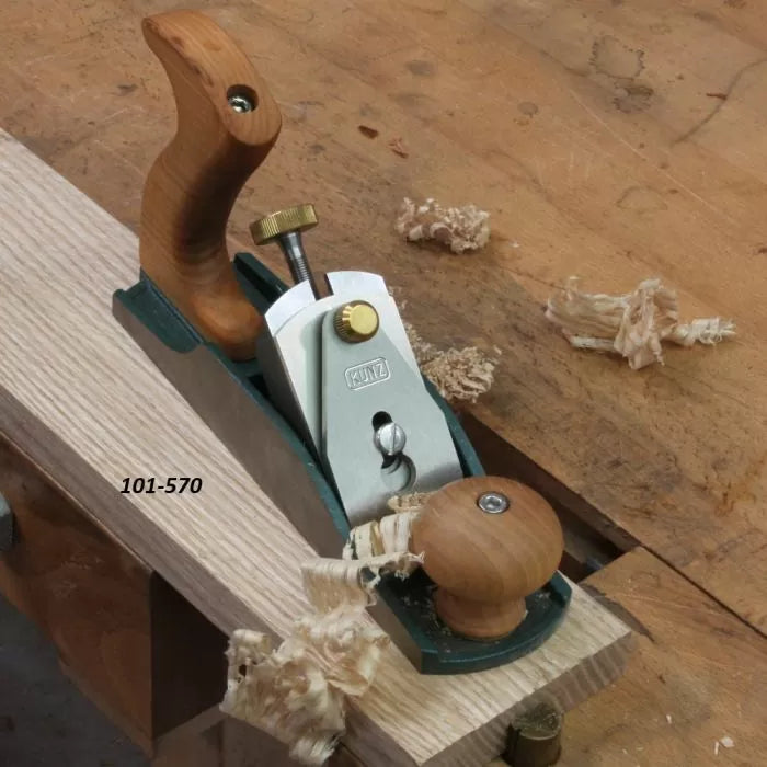 Bench hand plane smoothing wooden board with wood shavings on workbench