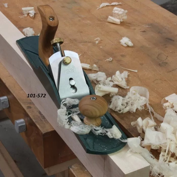 Bench hand plane on woodworking bench surrounded by wood shavings, labeled 101-572