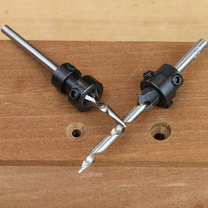 Countersink drill bits with depth stops positioned on a wooden board with drilled holes.
