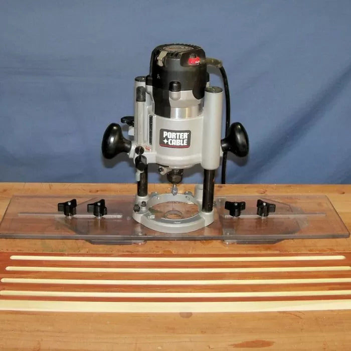 Woodworking router with edge guide on workbench, thin wood strips in foreground