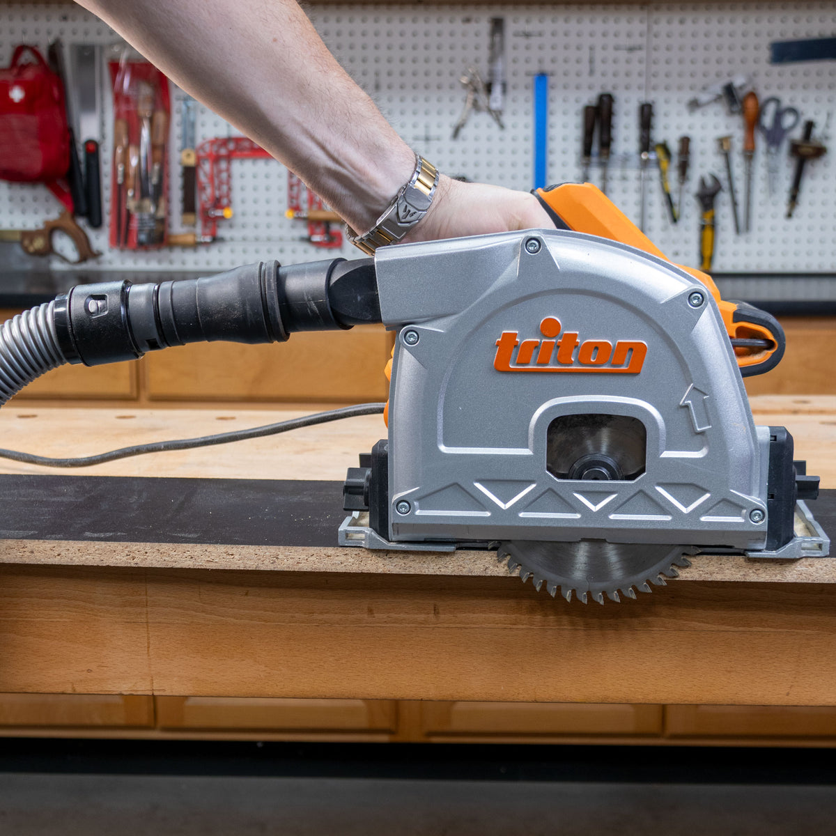 A triton track saw with a dust hose attached with a quick snap adapter.