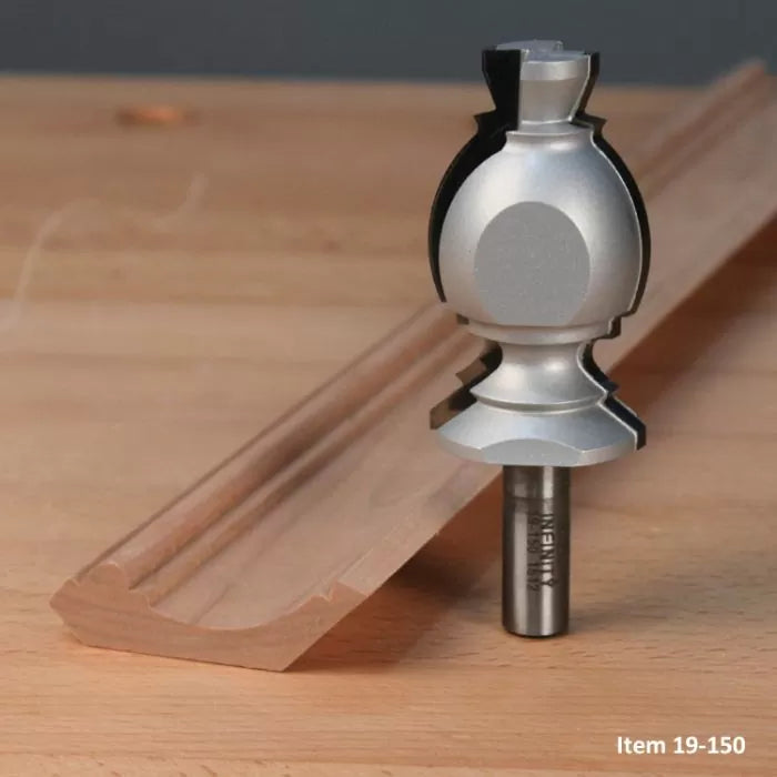 Crown molding router bit shown next to decorative wooden trim on a workbench
