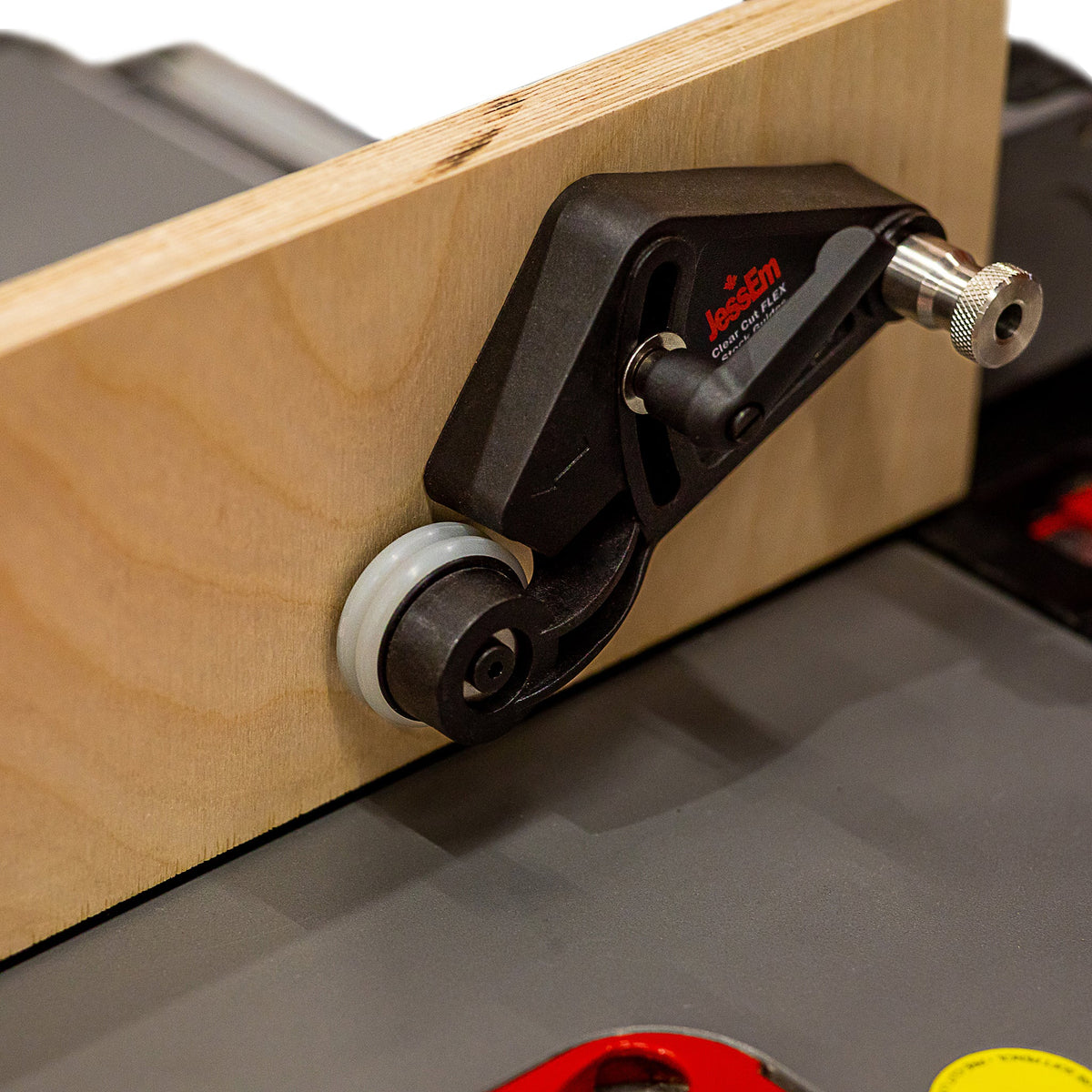 Woodworking router table featherboard with roller guide holding wood against fence