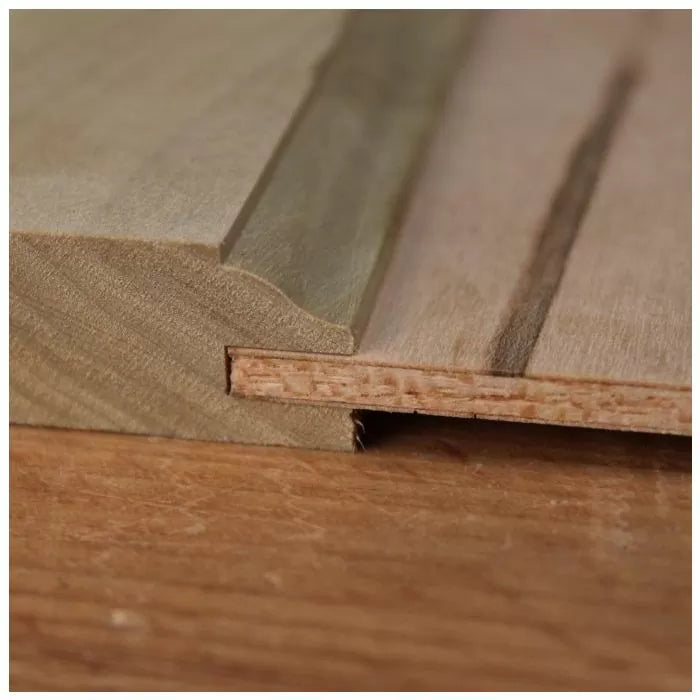 Close-up of tongue and groove wood joint on a flat wooden surface, ideal for woodworking projects.