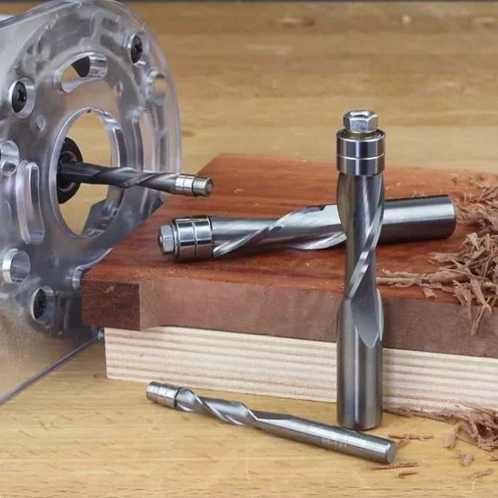 Upcut spiral router bits with bearings on wood, used for precision woodworking.