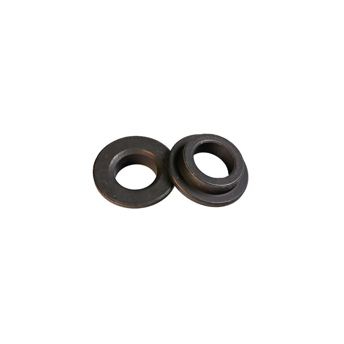 Pair of black saw blade bushings for woodworking tools on white background