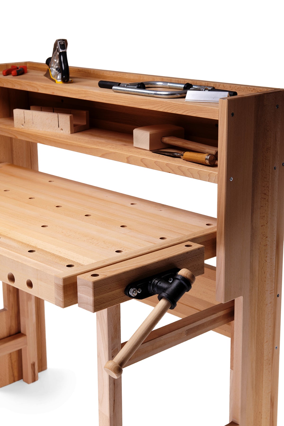 A light natural wood workbench with a peg-hole slatted desktop, open shelving, and a black-and-tan manual clamp mechanism on the right side, shown on a white background.