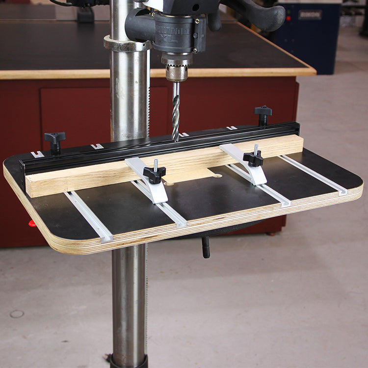 Drill press table with adjustable fence and hold-down clamps for woodworking