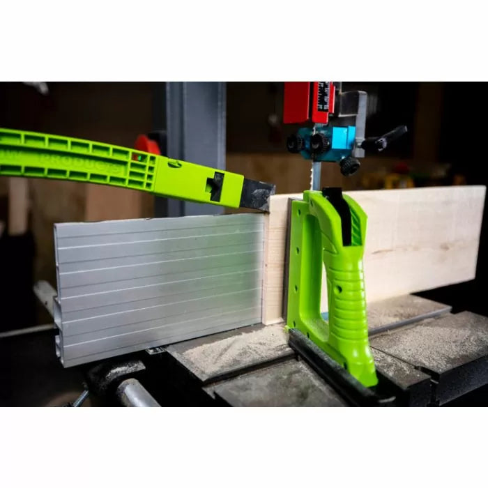 Bandsaw cutting wood with safety push block and aluminum fence, woodworking tool in use