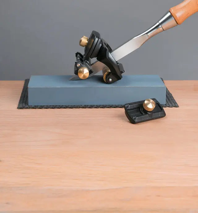 Chisel sharpening jig on a whetstone for precise woodworking tool honing