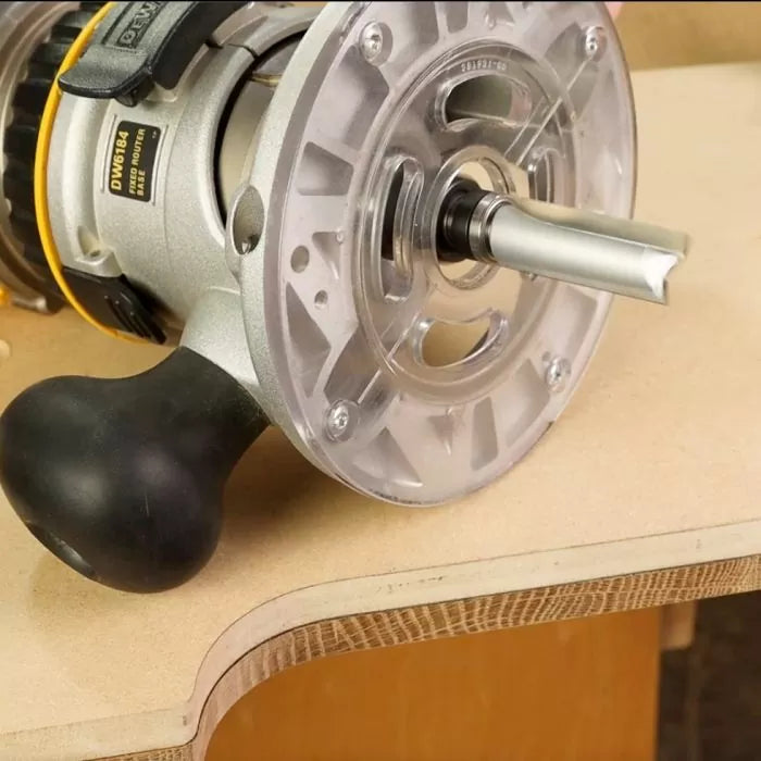 Woodworking router with roundover bit shaping the edge of a plywood workpiece