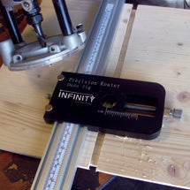 Infinity Precision Router Guide clamped to a track beside a plunge router