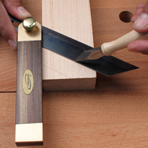Brass and rosewood sliding bevel gauge set against a board with a marking knife