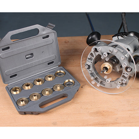 Brass router template guide bushing set in a case next to a router with clear base plate