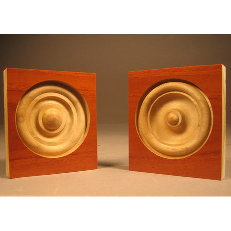 Two wooden plinth blocks with routed rosette patterns