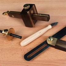 Brass and rosewood marking gauge, marking knife and sliding bevel on a bench