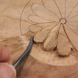 Woodworker carving flower pattern into wood with hand chisel, close-up of woodworking detail.