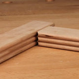 Close-up of mitered hardwood molding joint with decorative profile on wooden workbench