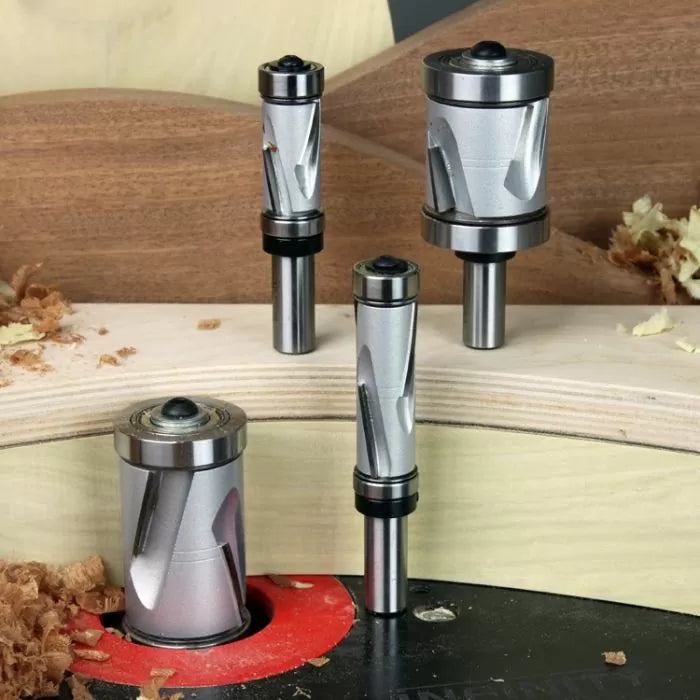 Set of carbide spiral flush trim router bits on woodwork backdrop with wood shavings