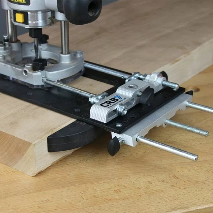 Woodworking router with CRB7 jig attached to a wooden board for precise edge routing.