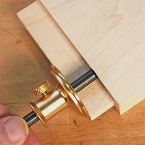 Brass marking gauge tool measuring wood for precise woodworking layout