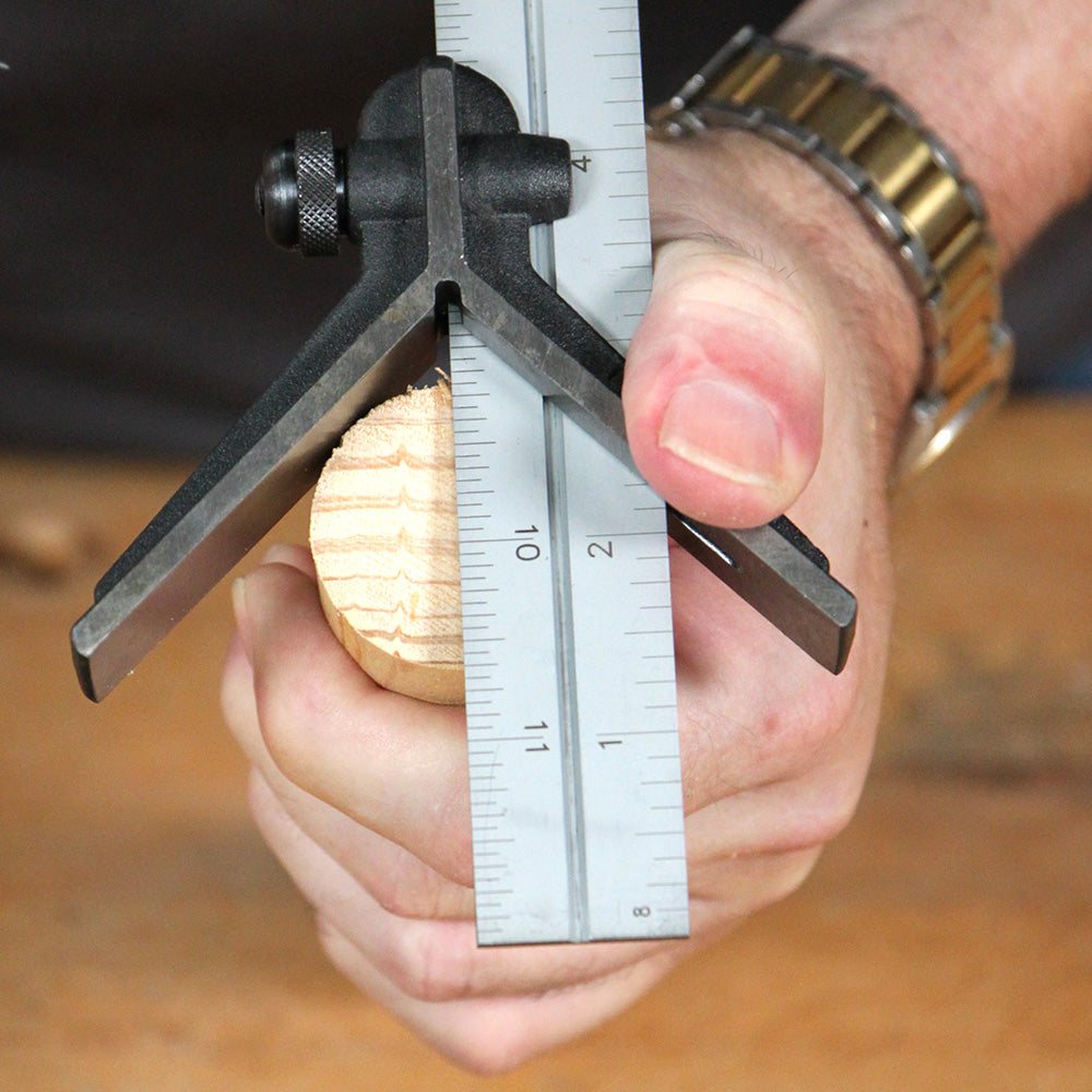 Woodworking center finder tool measuring round dowel on workbench