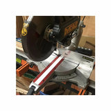 Sliding compound miter saw with red and white miter gauge in woodworking shop