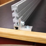 Aluminum T-track with mounting hardware installed on a woodworking table