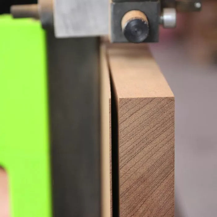 Close-up of bandsaw fence set up for precise resawing on a wood board
