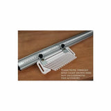 Featherboard woodworking accessory attached to a metal guide rail on a wooden surface