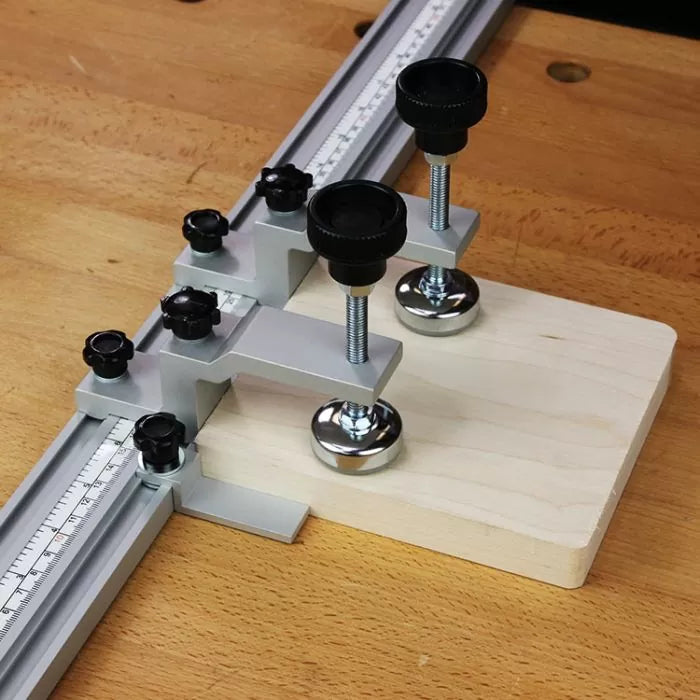 Woodworking drill guide jig with measuring scales and adjustable stops on workbench