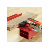 Woodworking bench with red clamping jig and toggle clamp securing a wood board