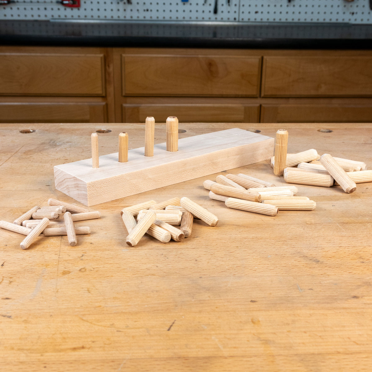 Wooden pegs and a wooden block on a wooden table with a workshop background