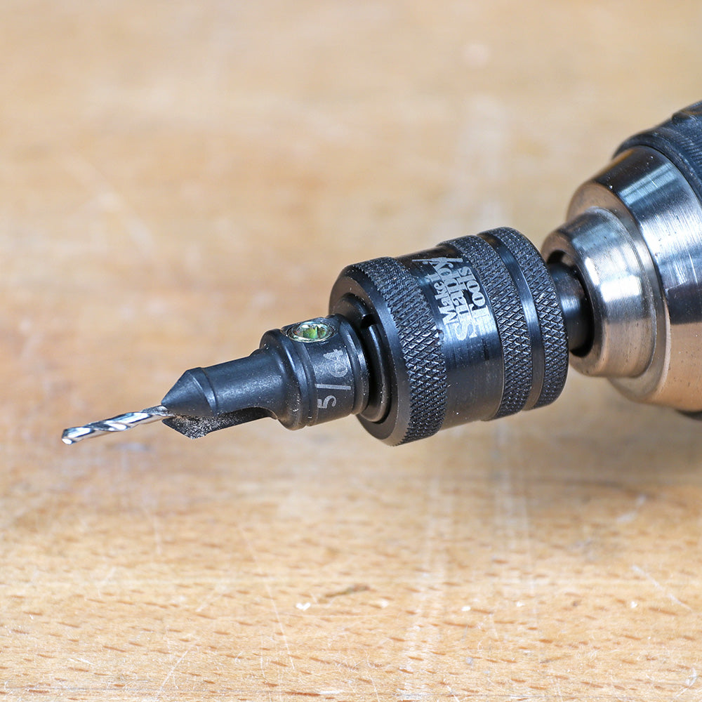 Close-up of a drill with countersink bit and depth stop for woodworking on a workbench