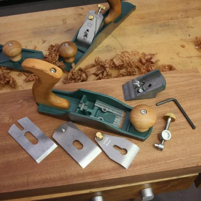 Woodworking hand plane with disassembled parts on a workbench, wood shavings visible