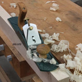 Bench hand plane with wooden handles on workbench, wood shavings and labeled 101-572