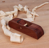 Wooden hand plane for woodworking with wood shavings on a workbench surface