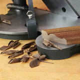 Woodworking jointer in use with wood shavings and freshly planed board on workbench