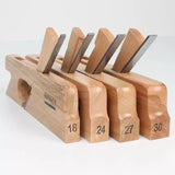Set of four wooden woodworking hand planes with labeled sizes and exposed steel blades.