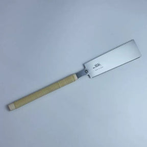 Japanese pull saw with fine teeth and ribbed beige handle on white background