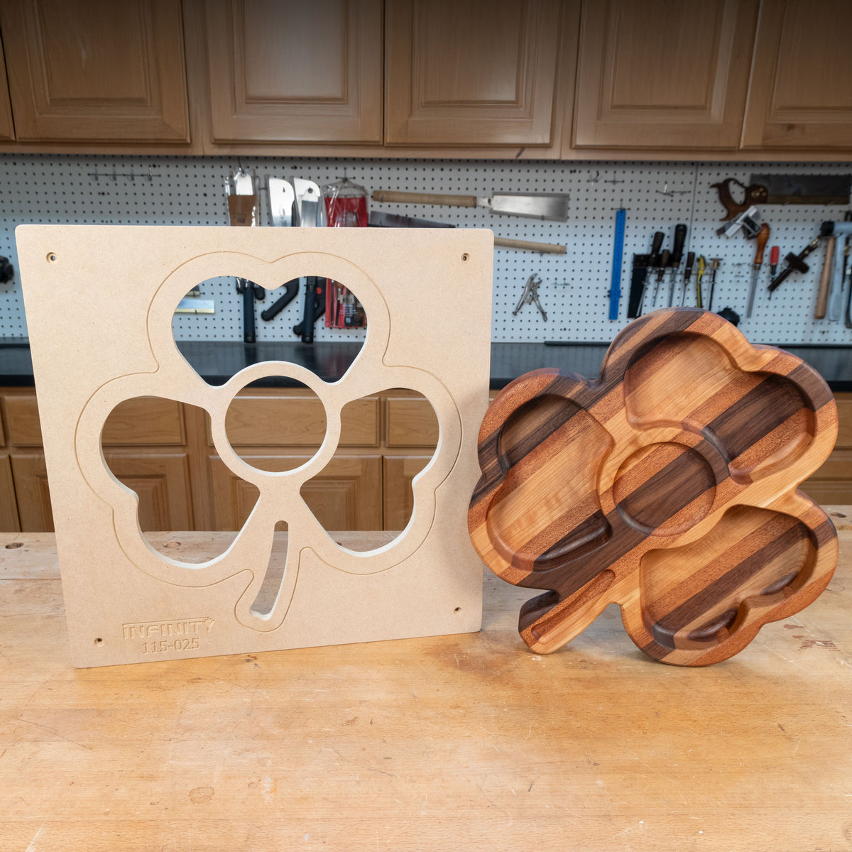 Shamrock-shaped woodworking template and finished wood tray on workbench in a workshop.
