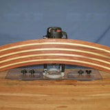 Woodworking router with straight edge guide shaping a curved laminated wood piece on workbench.