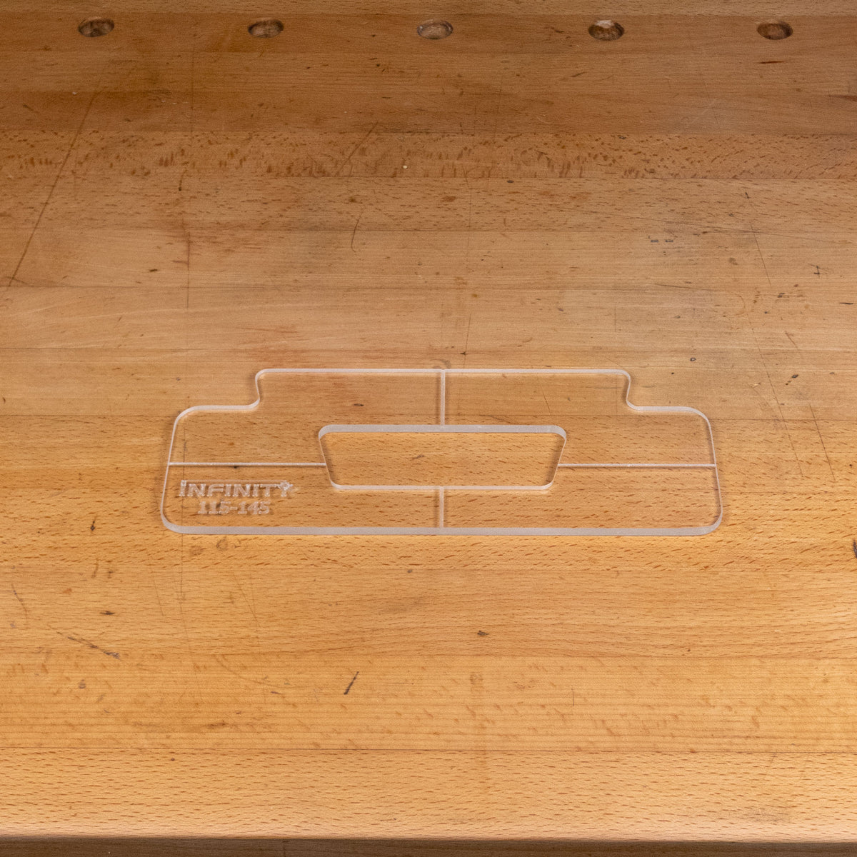 Clear acrylic handle template for woodworking, shown on a wooden workbench