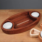 Wooden football-shaped serving tray with inlay, two ceramic bowls, on a wood table